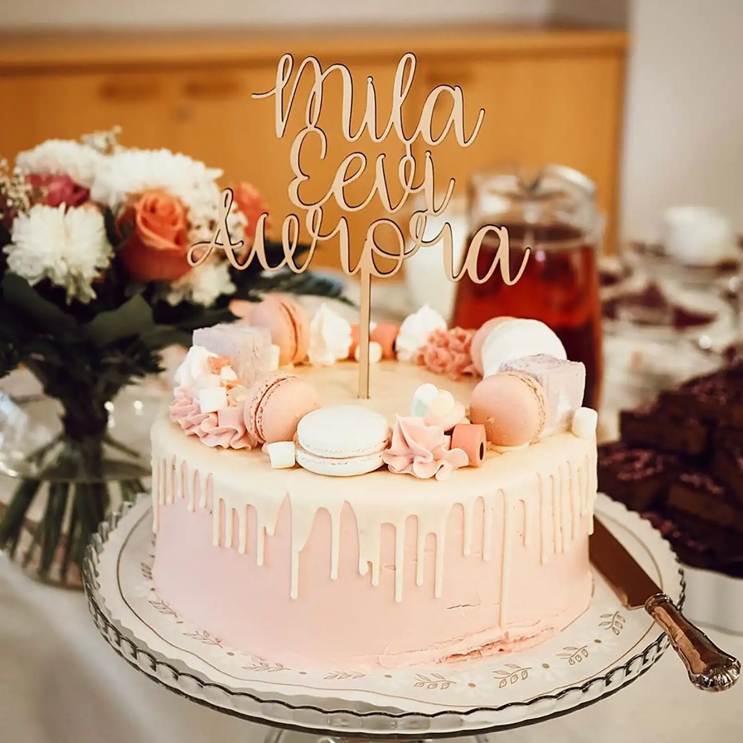 Vaaleanpunainen täytekakku nimikyltillä koristeltuna