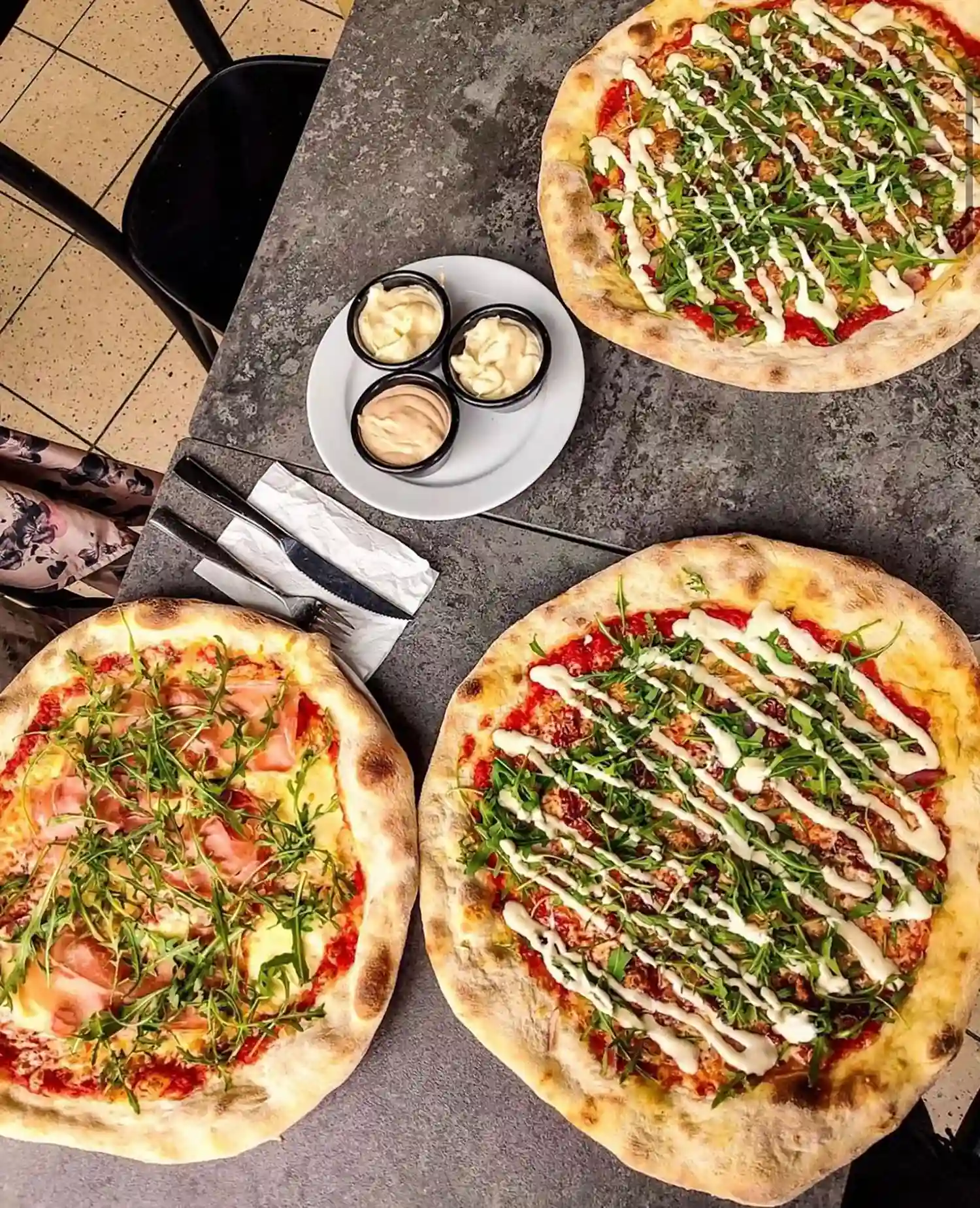 Kolme pizzerian pizzaa pöydällä