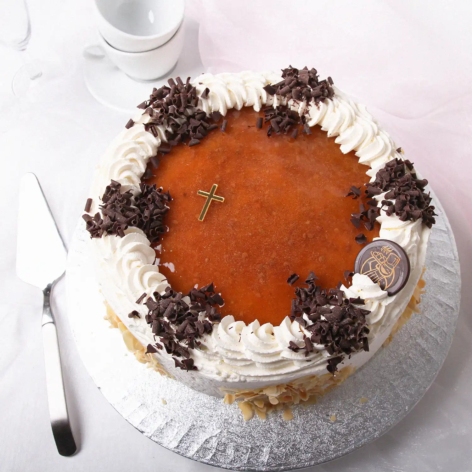 Kultaisella ristillä koristeltu lakkakakku