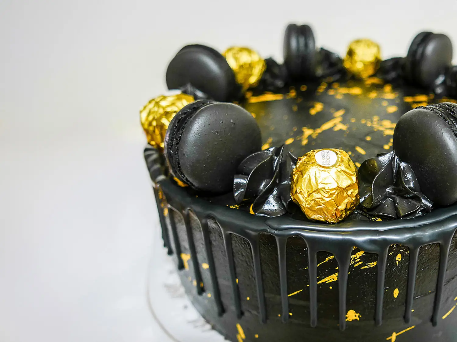 Musta hääkakku kultaisilla yksityiskohdilla