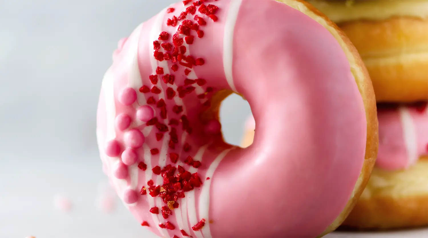 Vaaleanpunainen donitsi kuorrutteella