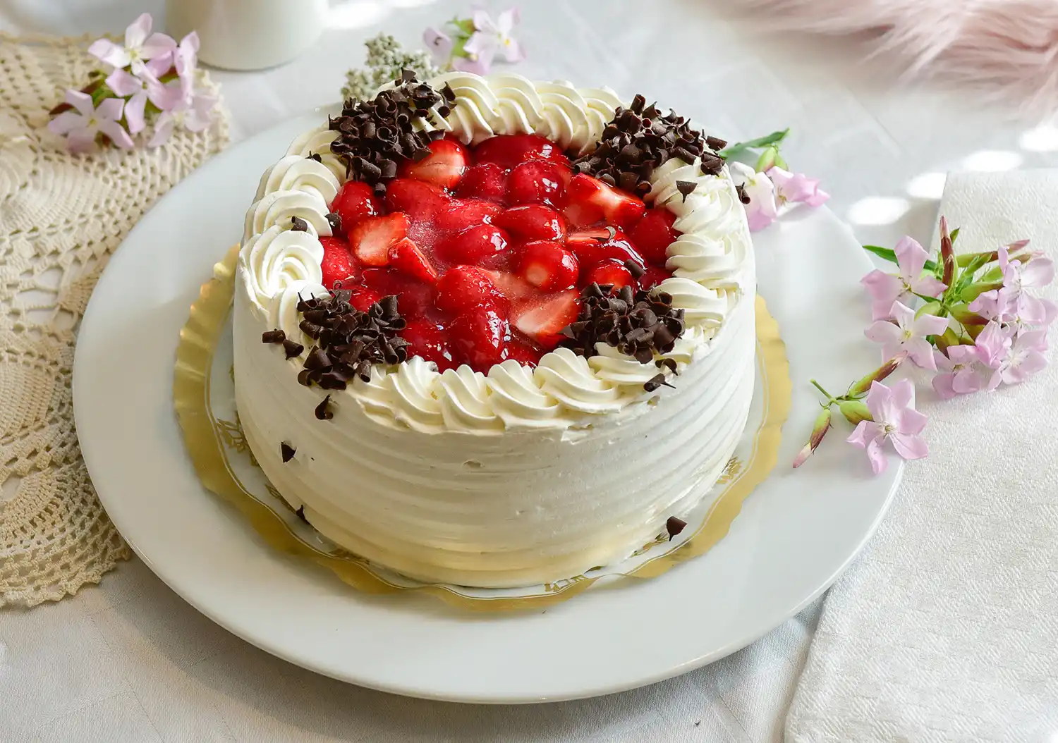 Marjoilla koristeltu mansikkatäytekakku pöydällä