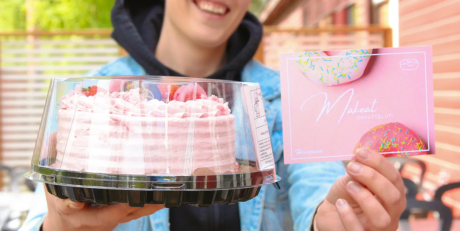 Onnittelukortti ja vadelmamoussekakku kädessä