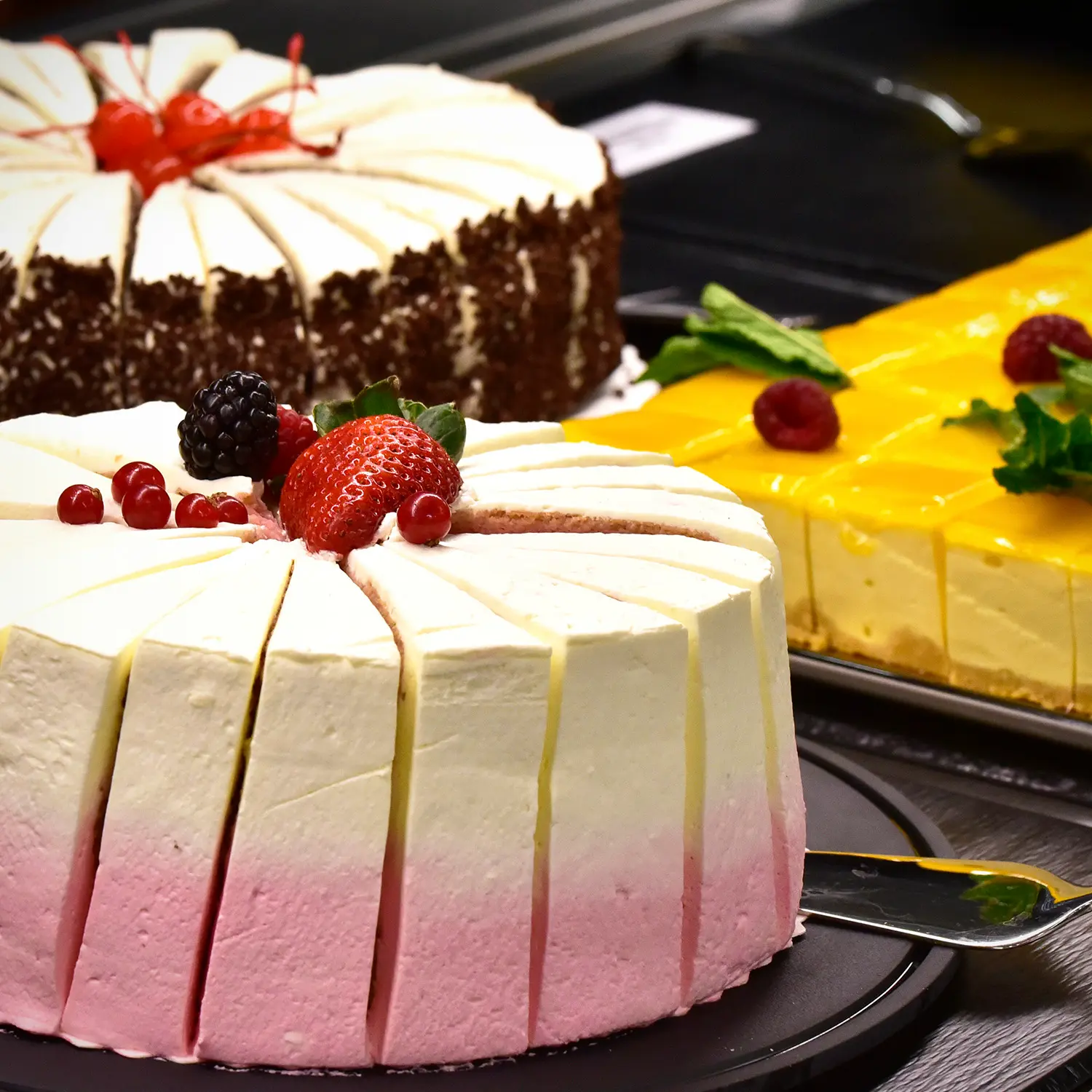 Paloiteltu vaaleanpunaisen ja valkoisen värinen täytekakku marjoilla