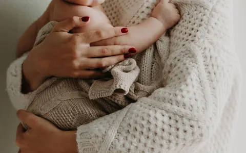 Pieni lapsi äidin sylissä