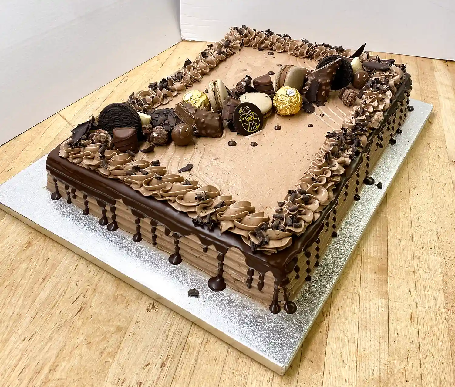 Suklaakarkeilla koristeltu levykakku hopeisella paksulla alustalla