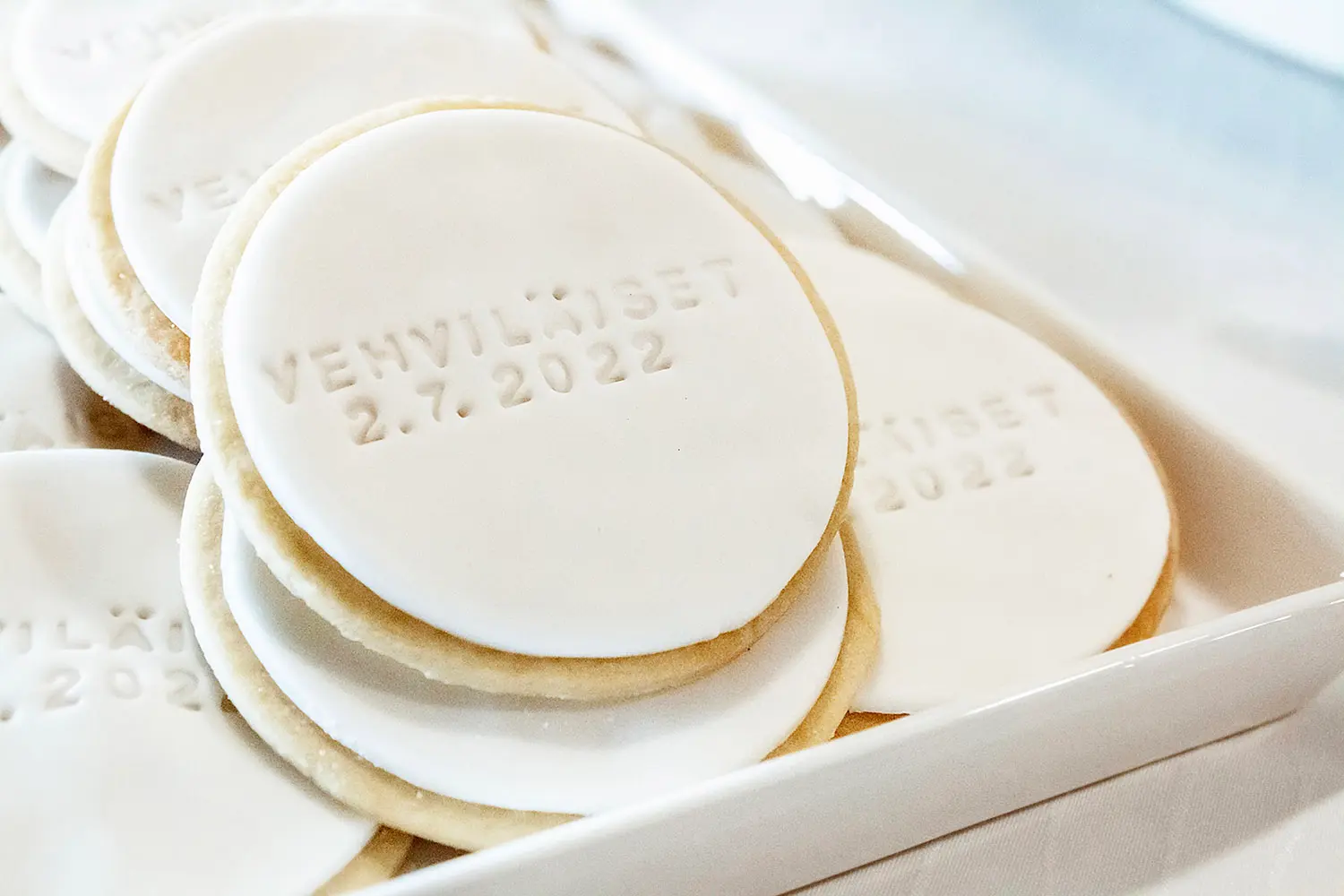 Hääjuhlien valkoiset nimikeksit sukunimellä ja päivämäärällä