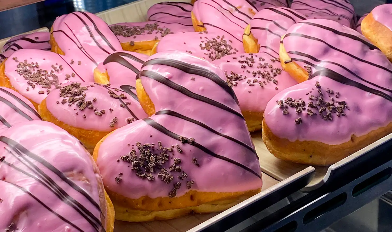 Sydämenmuotoiset vaaleanpunaiset munkit vitriinissä